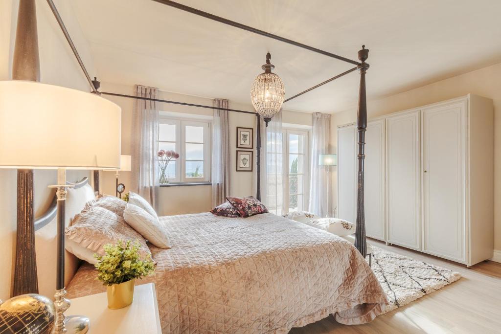 une chambre avec un grand lit et un lustre dans l'établissement VILLA ASTI: Where Luxury Meets Limitless View, à Capannori 129 autres photos