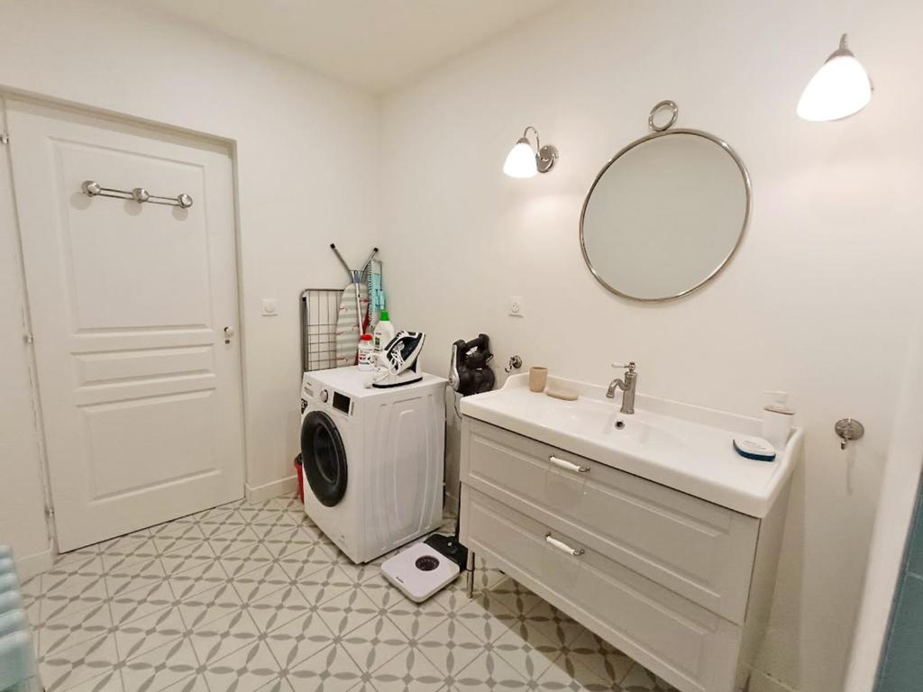 une salle de bain avec une machine à laver et un lavabo dans l'établissement Alphonse 52, grand T4, terrasse, wifi, 6 personnes, à Luchon
