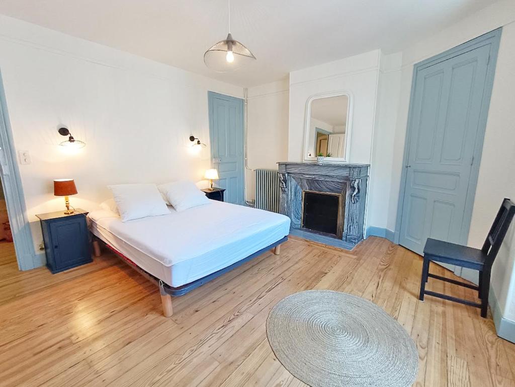 - une chambre avec un lit blanc et une cheminée dans l'établissement Alphonse 52, grand T4, terrasse, wifi, 6 personnes, à Luchon