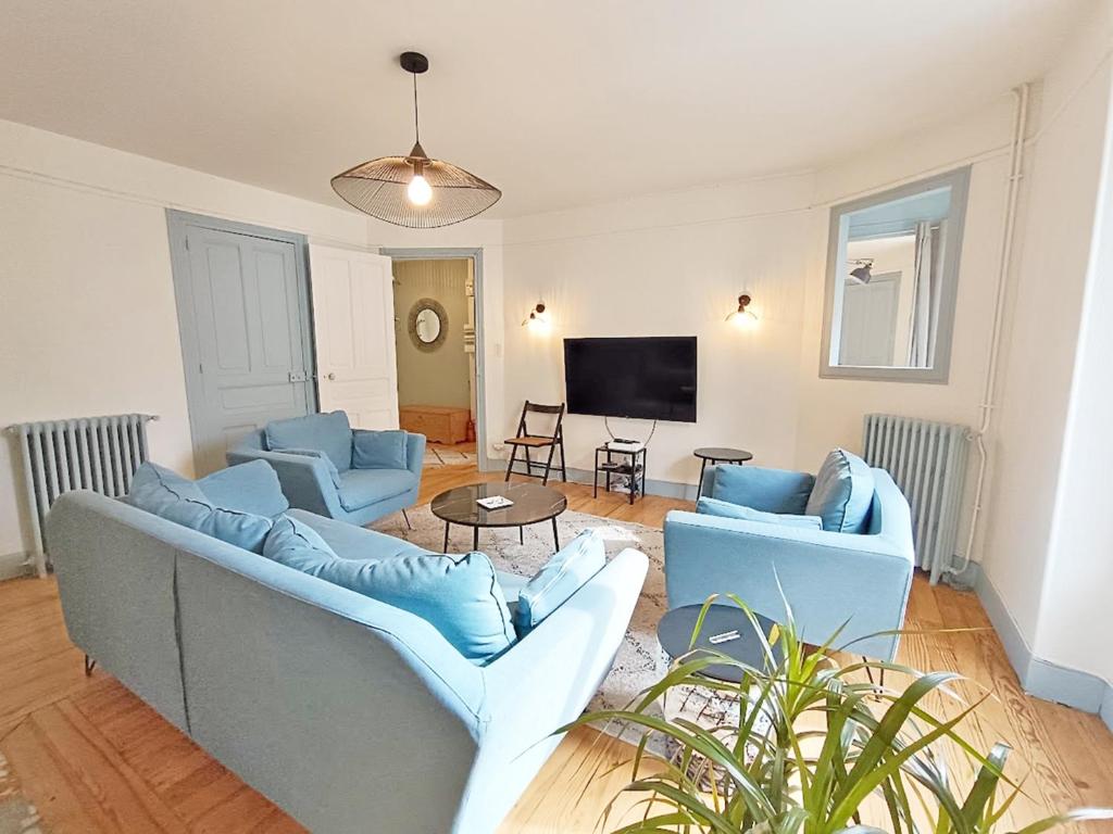 - un salon avec deux canapés bleus et une télévision dans l'établissement Alphonse 52, grand T4, terrasse, wifi, 6 personnes, à Luchon