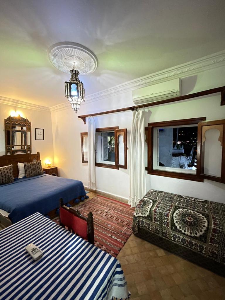 une chambre avec deux lits et un lustre dans l'établissement Dar Sababa, à Chefchaouen 37 autres photos