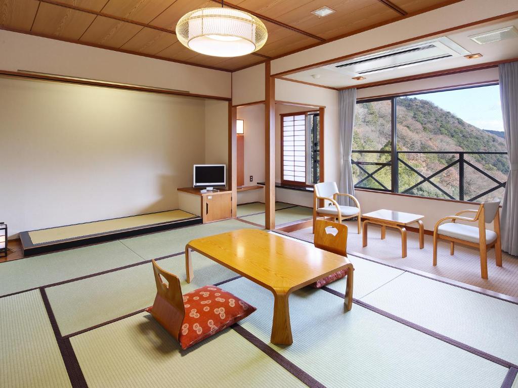 un salon avec une table et une grande fenêtre dans l'établissement Hakonenomori Okada, à Hakone