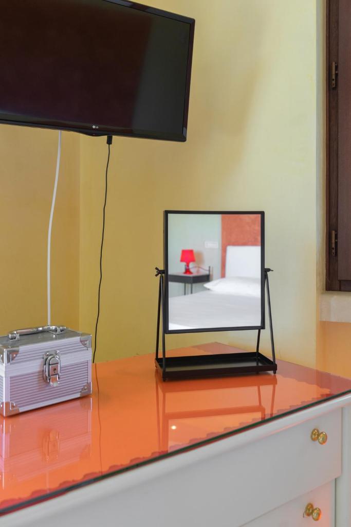 d'une table en verre avec une télévision. dans l'établissement Relais il Melograno, à Arnesano