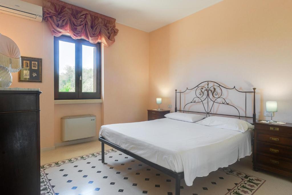 une chambre avec un lit et une fenêtre dans l'établissement Relais il Melograno, à Arnesano