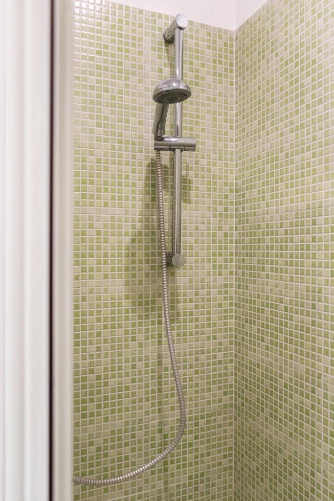 une douche avec pommeau de douche dans une salle de bain dans l'établissement Relais il Melograno, à Arnesano