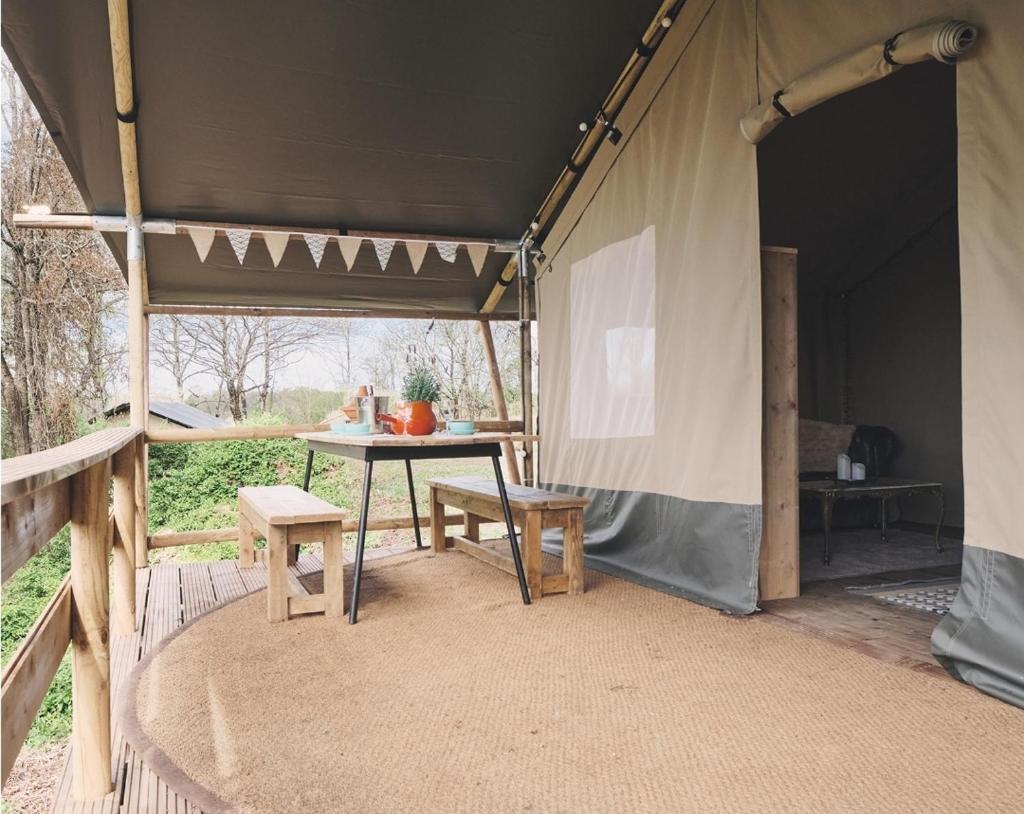 une tente avec une table et des chaises à l'intérieur dans l'établissement Camping d'Artagnan, à Margouët-Meymès