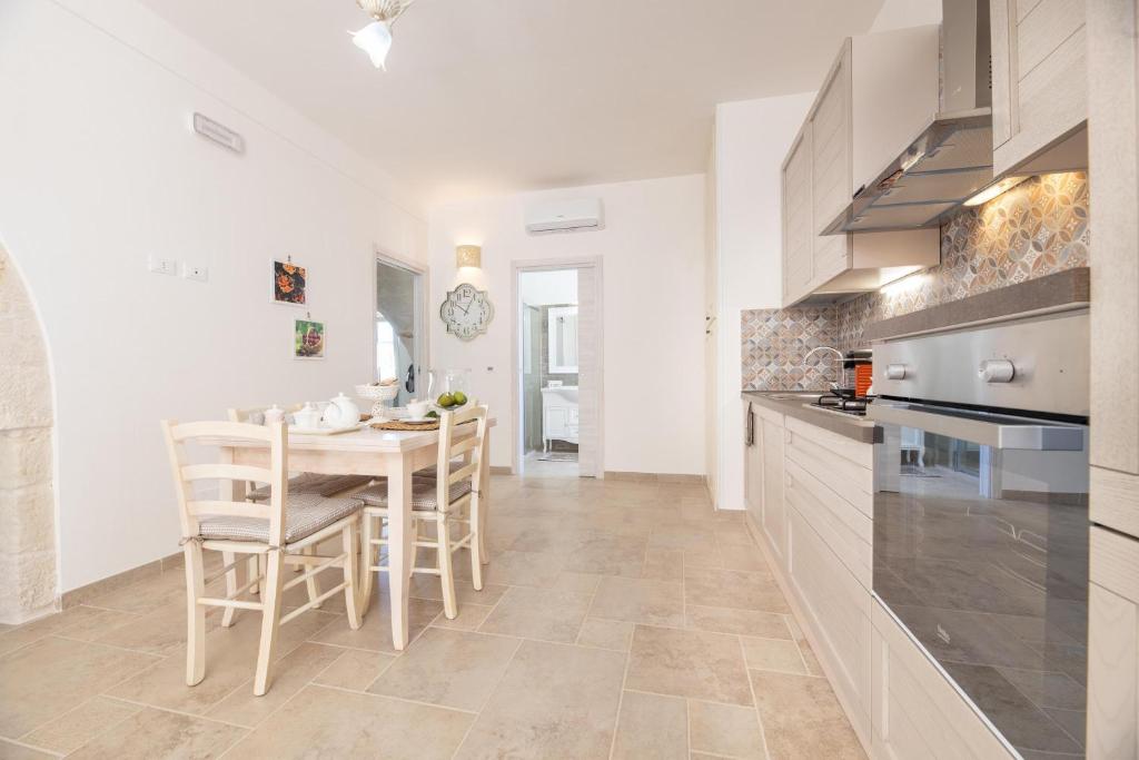 une cuisine avec une table et des chaises dans une pièce dans l'établissement Tenuta Del Sole, à Fasano