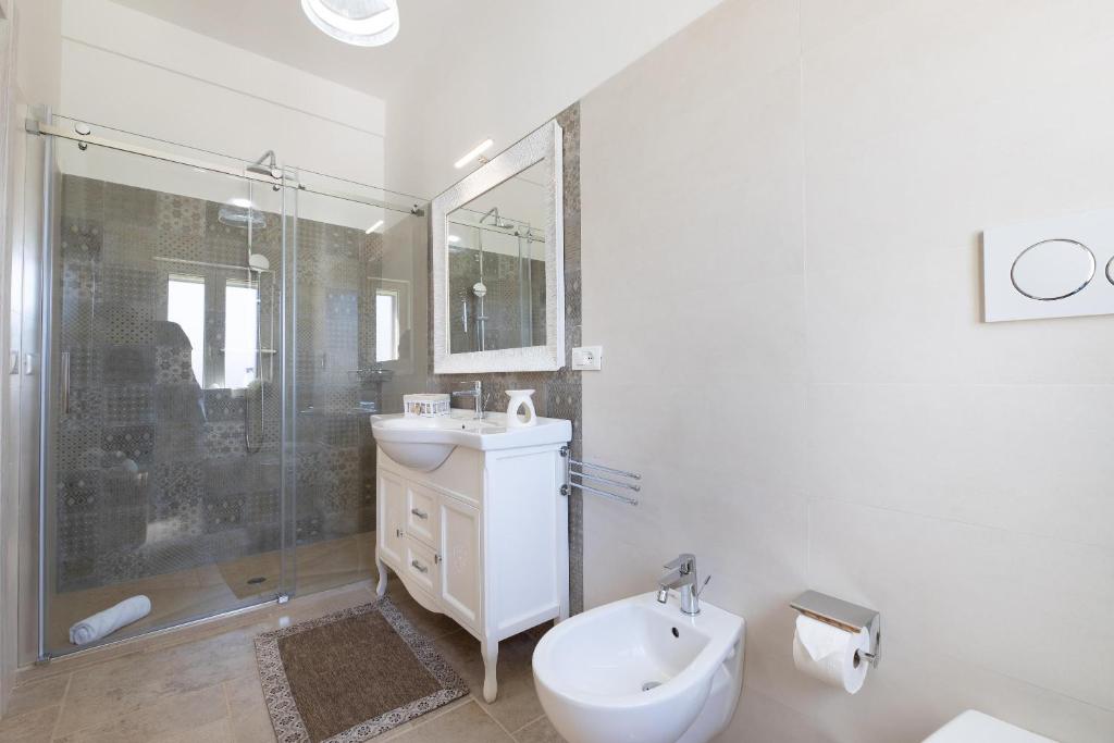 une salle de bain blanche avec un lavabo et une douche dans l'établissement Tenuta Del Sole, à Fasano