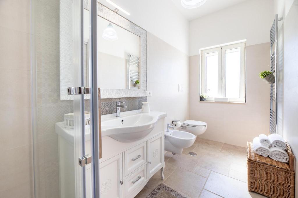 une salle de bain blanche avec un lavabo et des toilettes dans l'établissement Tenuta Del Sole, à Fasano 19 autres photos