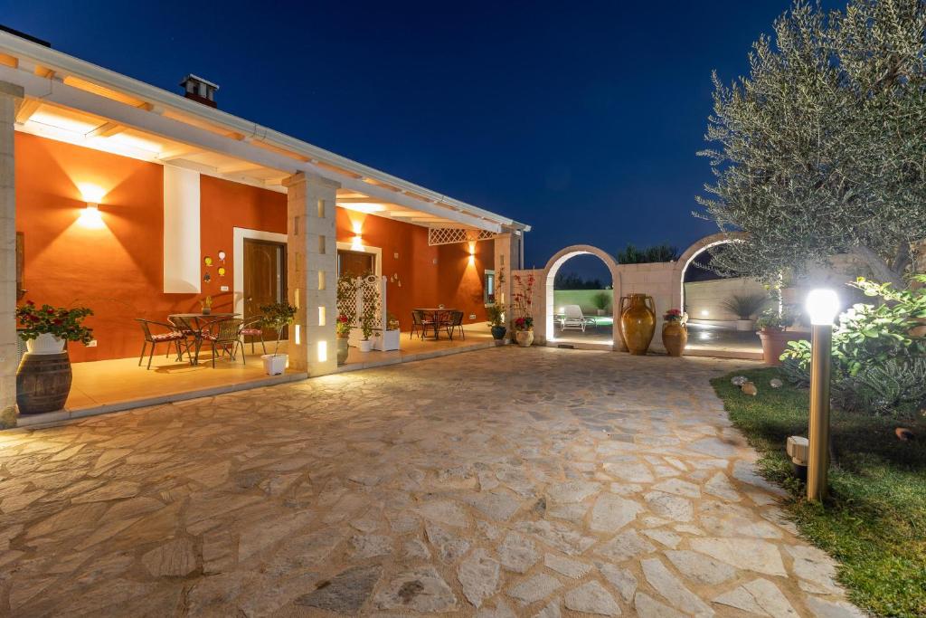 - une terrasse d'une maison éclairée la nuit dans l'établissement Tenuta Del Sole, à Fasano