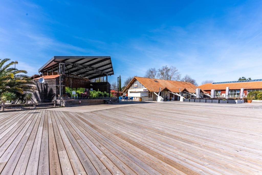 une grande terrasse en bois devant un bâtiment dans l'établissement Mobilhome a La reserve, à Gastes