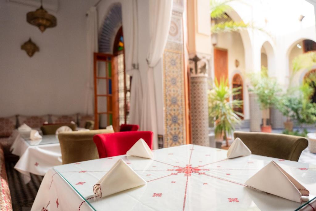 une salle à manger avec des tables, des chaises et un tissu de table blanc dans l'établissement Riad Al Ansari, à Fès 37 autres photos