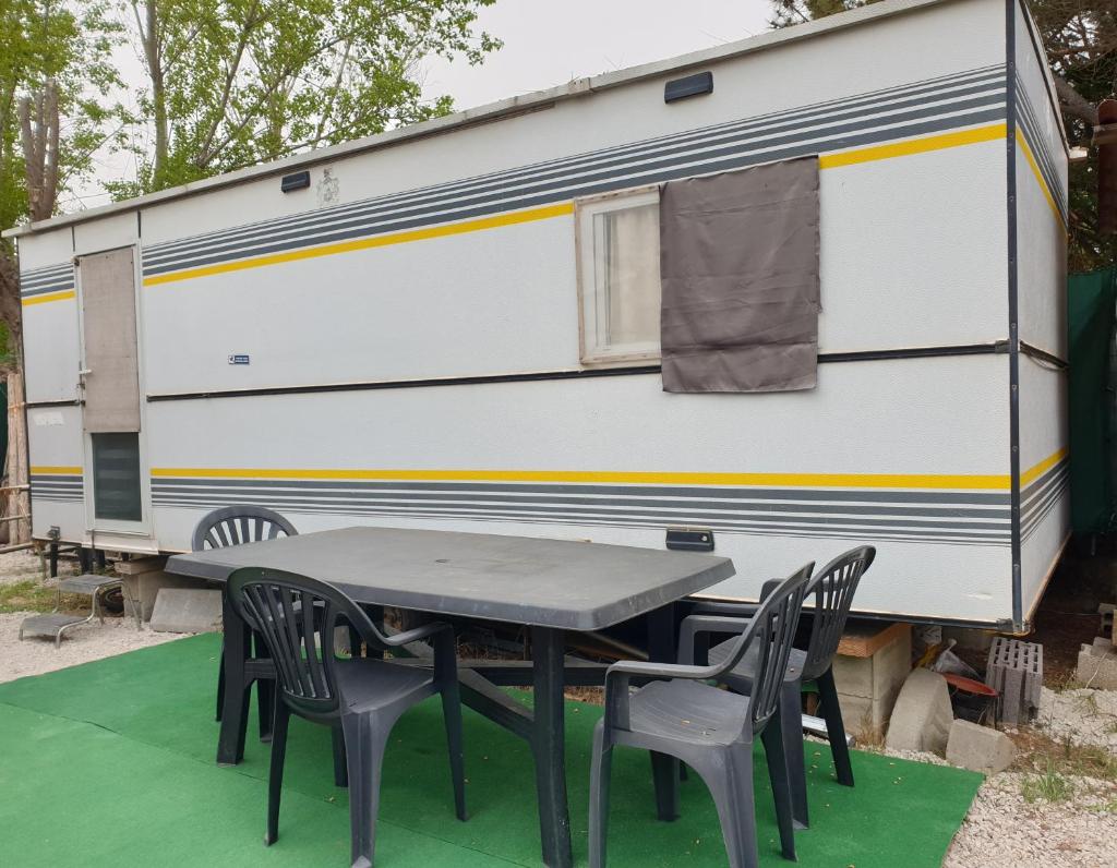 d'une table et de chaises devant une réserve dans l'établissement Mobil home chez un particulier pour 1 à 4 personnes à 800 m de la plage de Valras pas dans un camping, à Sérignan