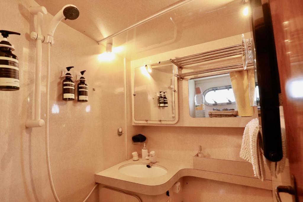 une petite salle de bain avec un lavabo et un miroir dans l'établissement YACHT DEAUVILLE, à Deauville