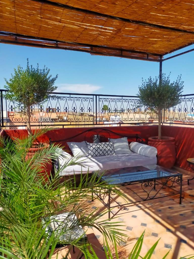 Cette chambre comprend un lit et un balcon orné de plantes. dans l'établissement Le riad de l'étoile ocre - COTG, à Marrakech 37 autres photos