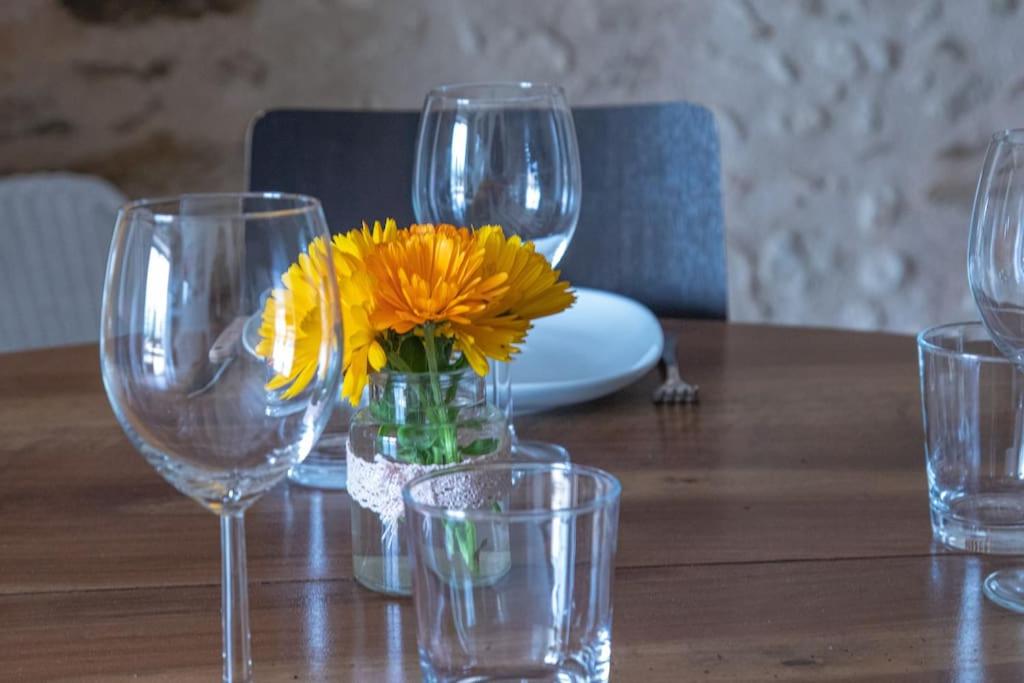 - une table avec des verres à vin et un vase avec des fleurs jaunes dans l'établissement Gîte de charme et spa prés d'Albi , Au Mas de Bel Air, à Arthès 37 autres photos