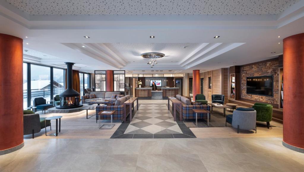 un hall d'hôtel avec des chaises et des tables dans l'établissement MGM Hôtels & Résidences - Hôtel Alpen Lodge, à La Rosière 37 autres photos