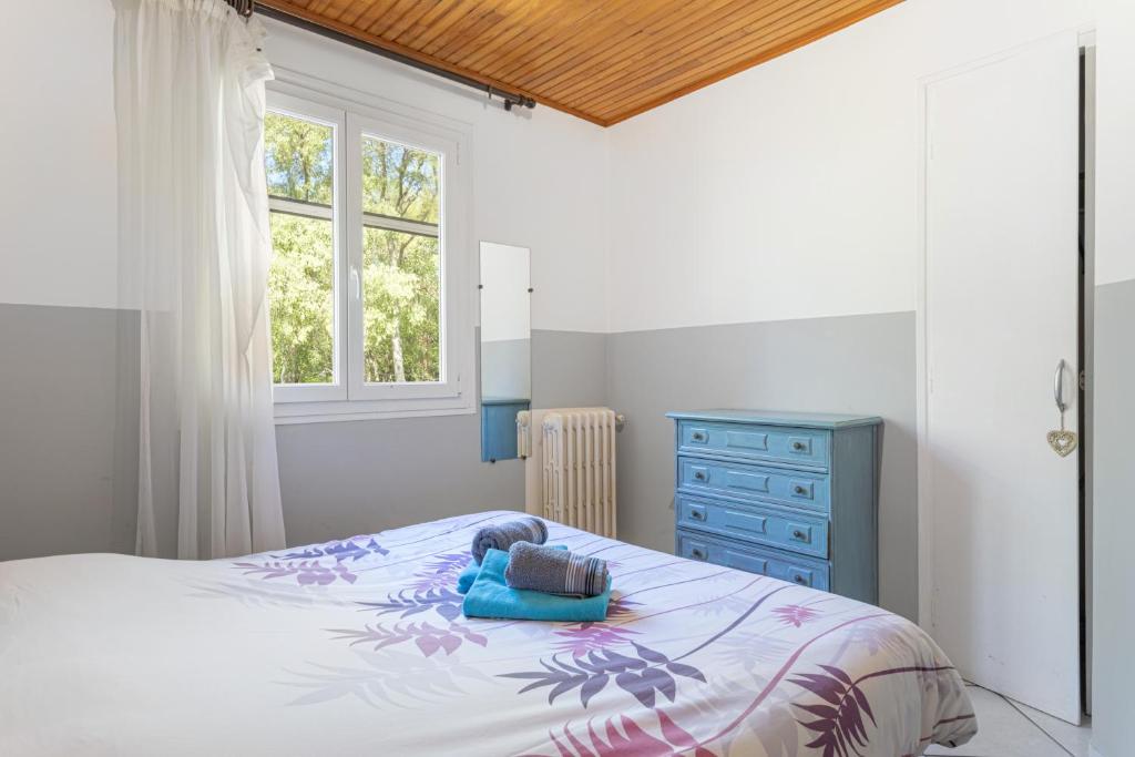 - une chambre avec un lit, une commode bleue et une fenêtre dans l'établissement Gite 4 entre 2 et 4 personnes, à Reynès