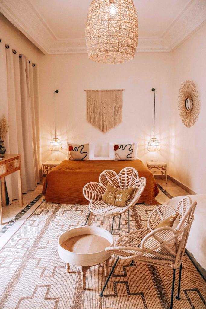 une chambre avec un lit, une table et des chaises dans l'établissement Riad Ksar Fawz & Spa, à Marrakech