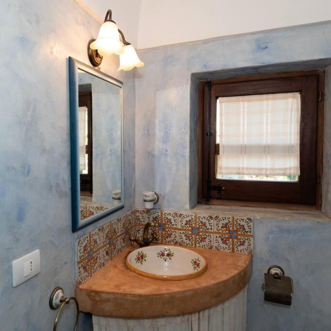 une salle de bain avec un lavabo et un miroir dans l'établissement Dammuso Tramonto, à Pantelleria 35 autres photos