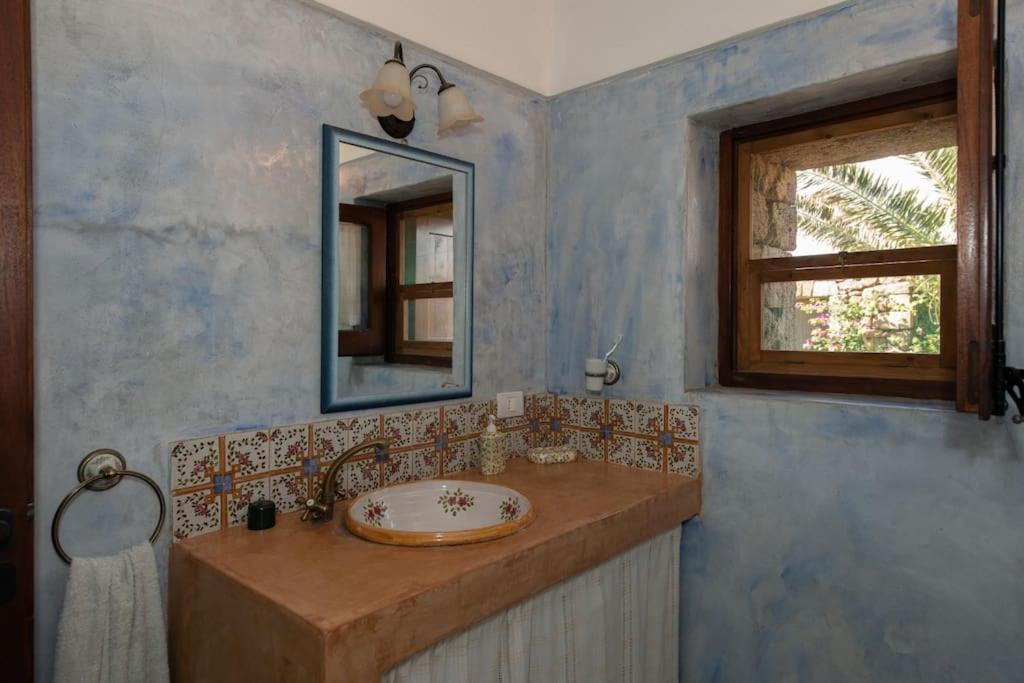 une salle de bain avec un lavabo et un miroir dans l'établissement Dammuso Tramonto, à Pantelleria