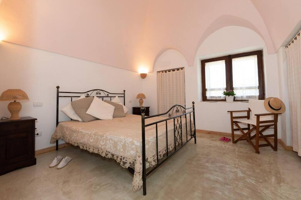 une chambre avec un lit, une table et une chaise dans l'établissement Dammuso Tramonto, à Pantelleria