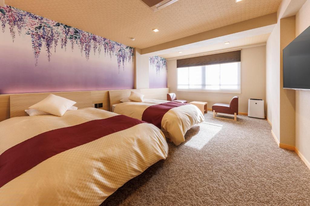 - une chambre avec 2 lits et une télévision dans l'établissement Izu atagawa Yubana mankai -Adult Only-, à Higashiizu