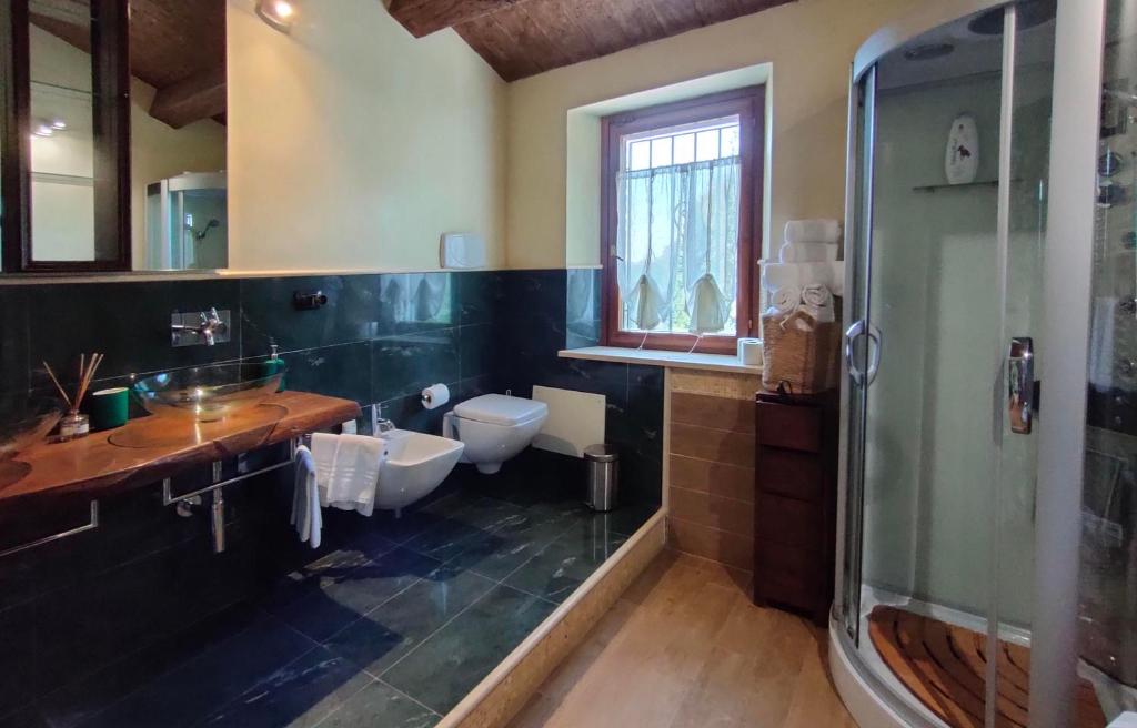 une salle de bain avec toilettes, lavabo et douche dans l'établissement Villa Daya by BarbarHouse, à Carignano