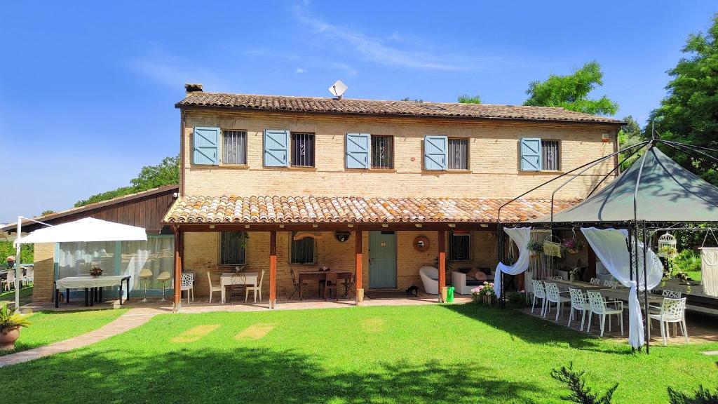 une grande maison avec une cour et une tente dans l'établissement Villa Daya by BarbarHouse, à Carignano