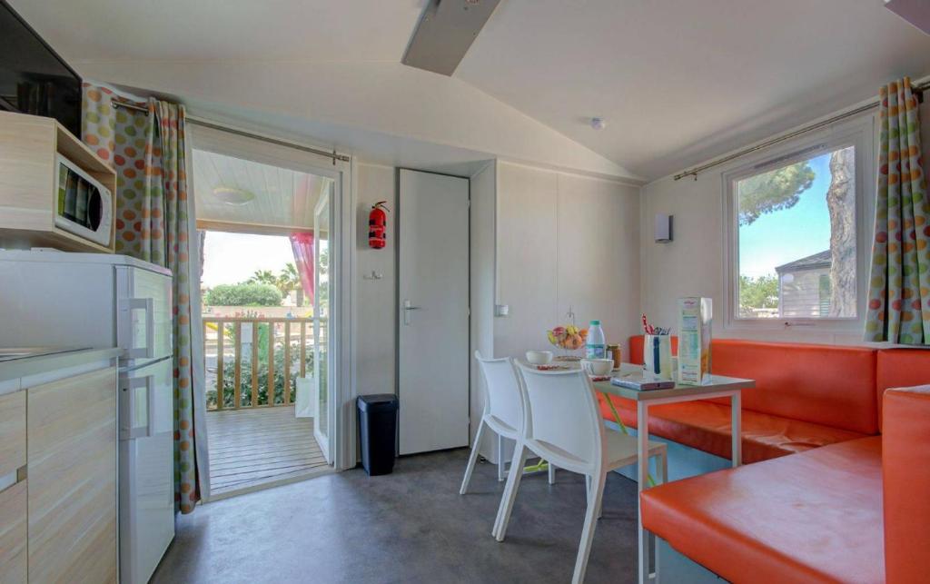 une cuisine et une salle à manger avec une table et des chaises dans l'établissement Camping Les Jardins d'Agathe - Maeva, au Grau-dʼAgde