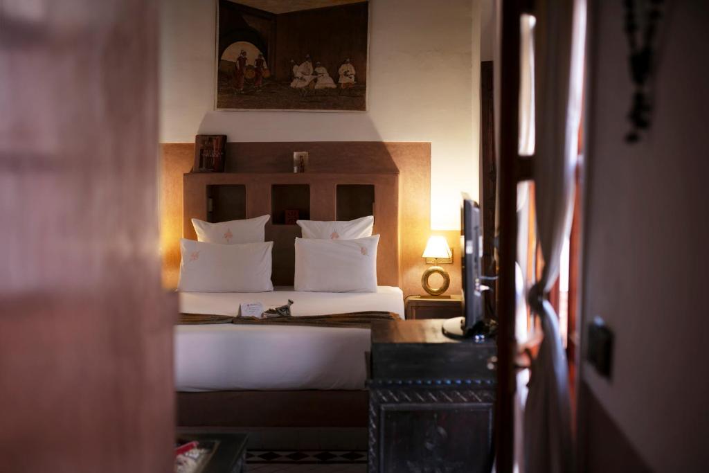 une chambre avec un lit avec des oreillers blancs dans l'établissement Riad Alili, à Marrakech