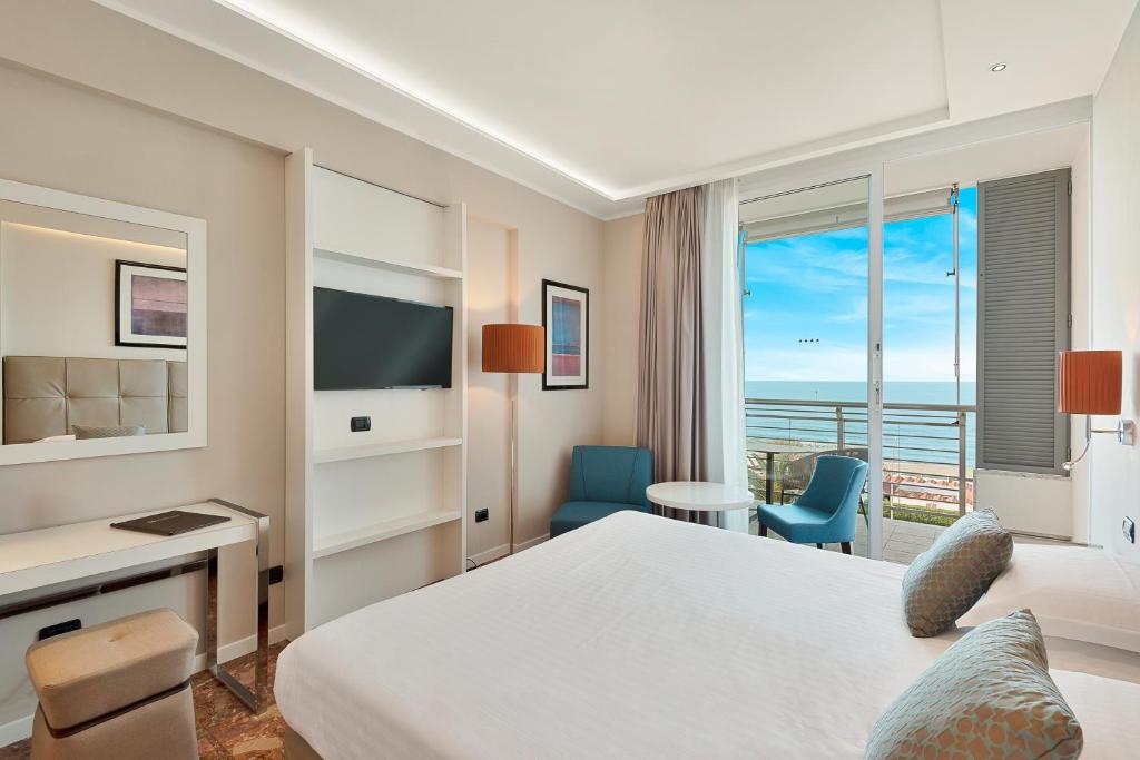 une chambre d'hôtel avec un lit et une vue sur l'océan dans l'établissement Hotel Excelsior, à Marina di Massa