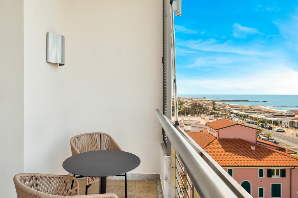 un balcon avec deux chaises et une vue sur l'océan dans l'établissement Hotel Excelsior, à Marina di Massa