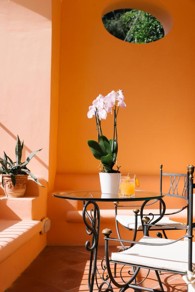 - une table avec des fleurs dans une chambre aux murs orange dans l'établissement Villa Principe Giovanni, à Positano