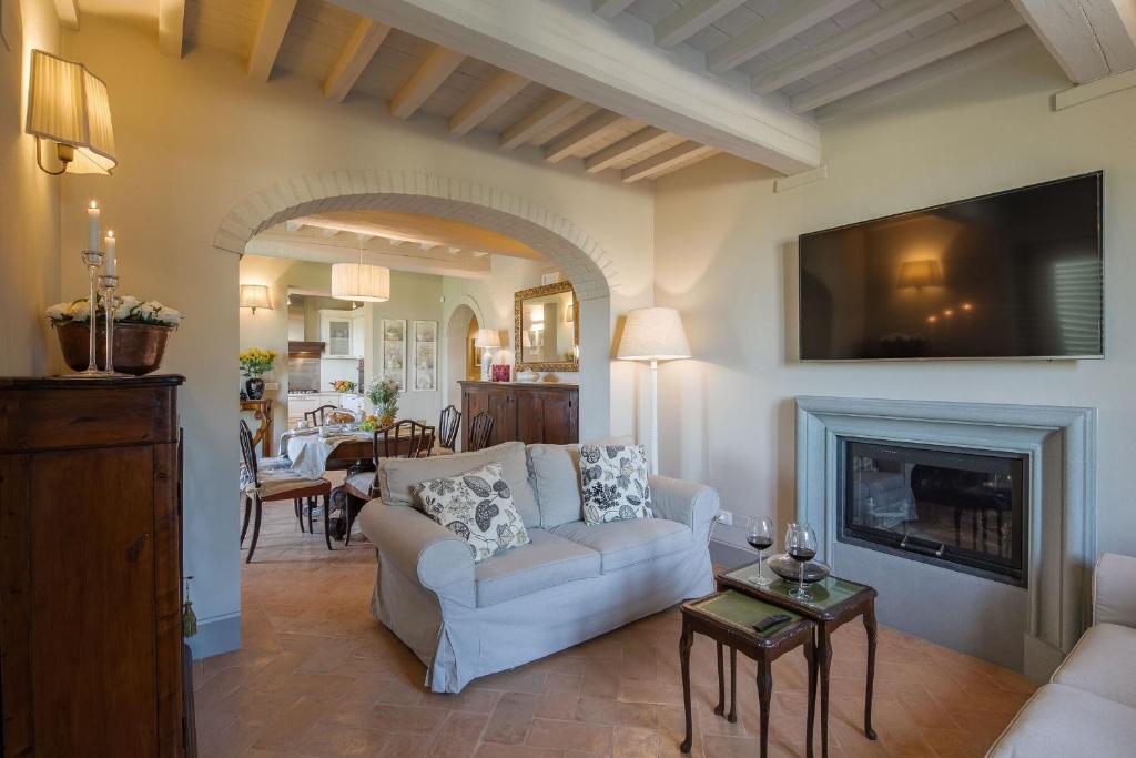 un salon avec un canapé et une cheminée dans l'établissement Villa Chiara, à Cortone