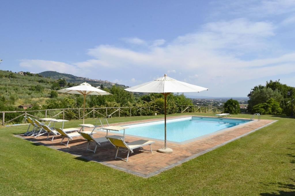 une piscine avec des chaises et des parasols à côté dans l'établissement VILLA SAN PIETRO, à Cortone