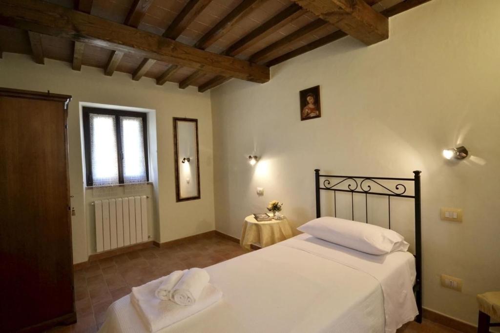 une chambre avec un lit avec des draps blancs et une fenêtre dans l'établissement Villa Fiordaliso, à Poggioni 24 autres photos