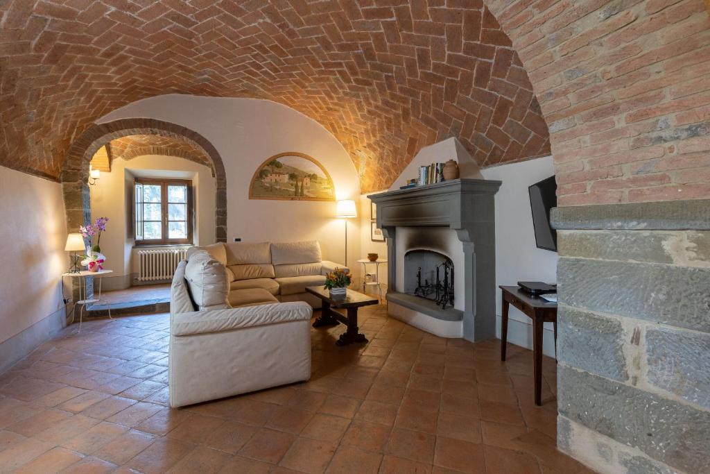 un salon avec un canapé et une cheminée dans l'établissement VILLA SAN PIETRO, à Cortone