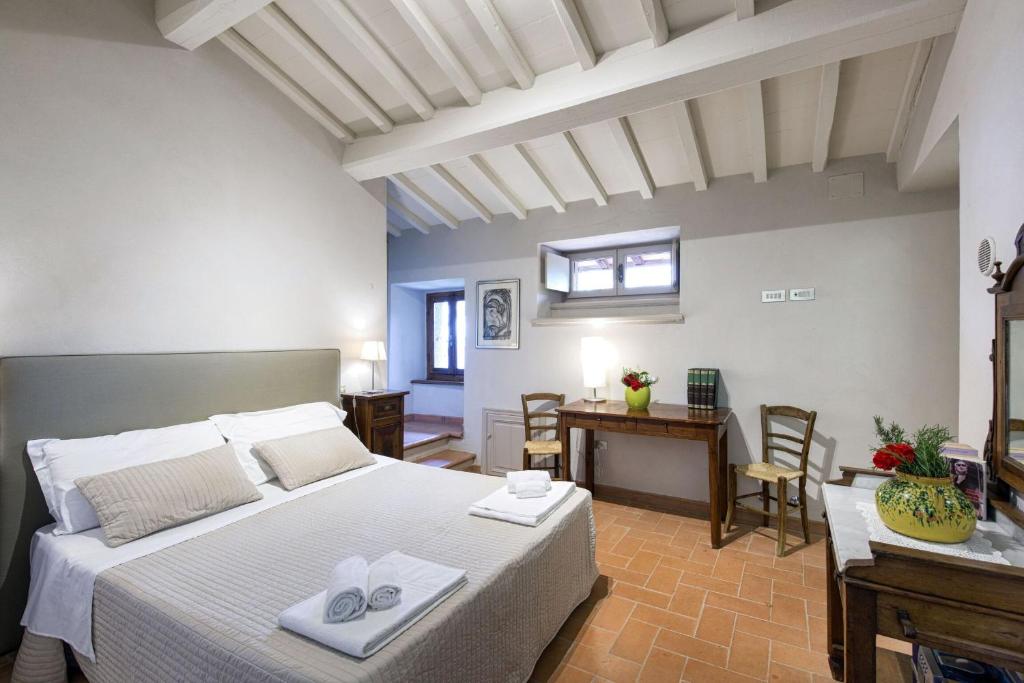 une chambre avec un lit et un bureau dans une pièce dans l'établissement Villa Magnolia, à Cortone