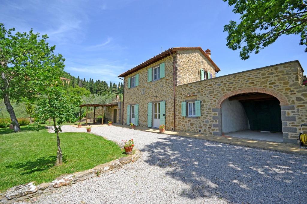 une vue extérieure d'une maison en pierre avec garage dans l'établissement Villa Il Palazzone, à Cortone