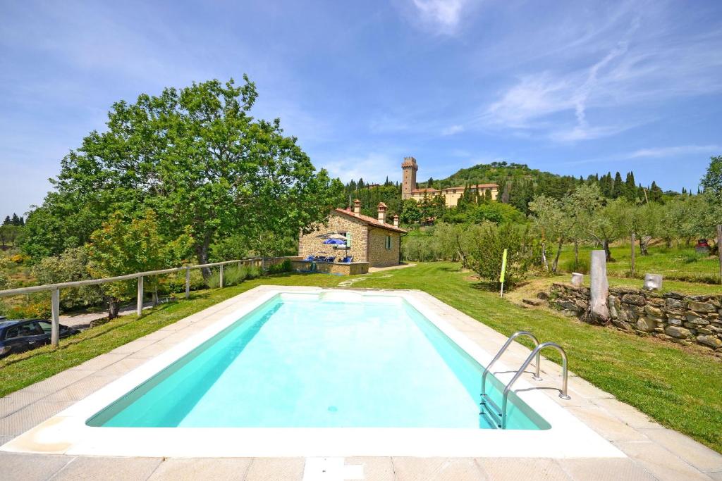 une grande piscine avec une maison en arrière-plan dans l'établissement Villa Il Palazzone, à Cortone