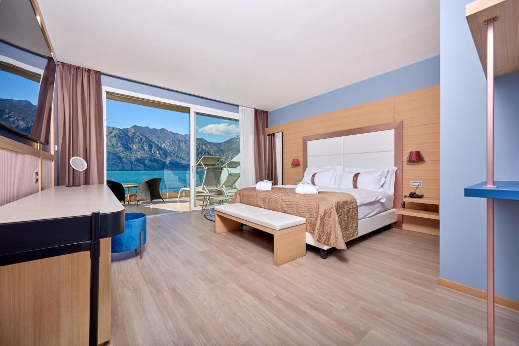 une chambre d'hôtel avec un lit et une grande fenêtre dans l'établissement Hotel Castello Lake Front, à Malcesine