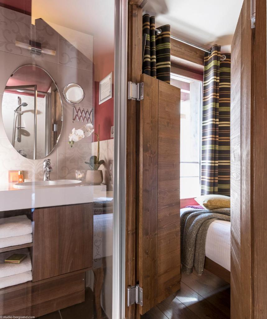 une salle de bain avec un lavabo et un miroir dans l'établissement Le Hameau du Kashmir, à Val Thorens 37 autres photos
