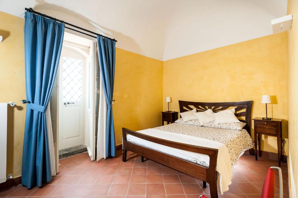 - une chambre avec un lit doté de rideaux bleus et d'une fenêtre dans l'établissement Villa Eremo Sant'Emilia, à Trecastagni 26 autres photos