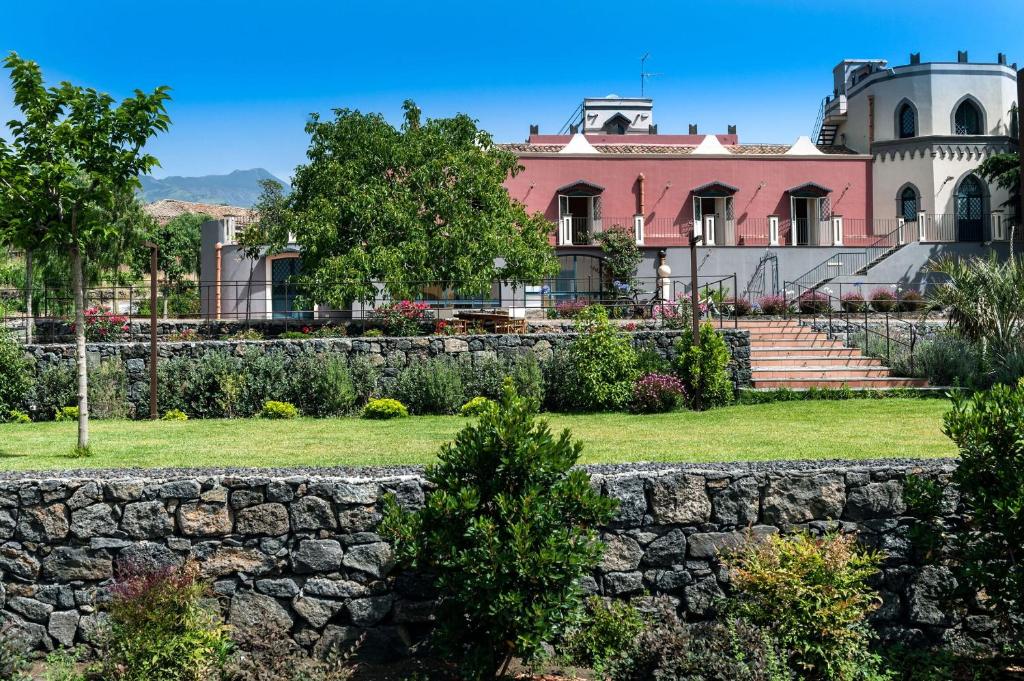 une maison ancienne avec un mur en pierre devant dans l'établissement Villa Eremo Sant'Emilia, à Trecastagni
