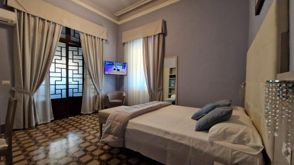une chambre avec un lit et une télévision au mur dans l'établissement Hotel Giardino, à Lido di Camaiore