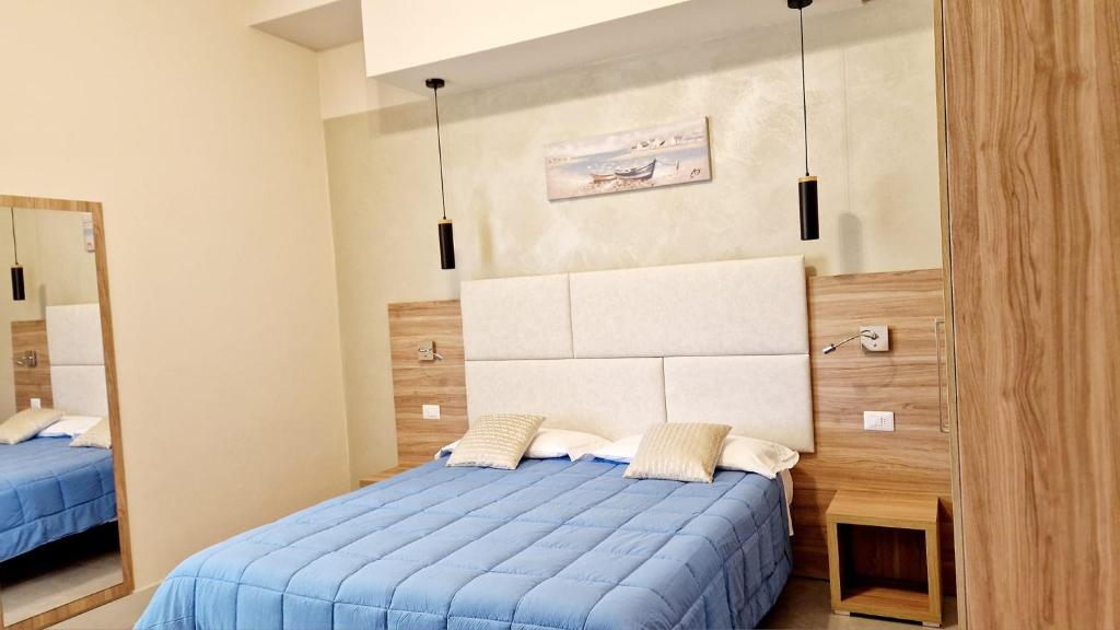 une chambre avec un lit bleu et un miroir dans l'établissement Hotel Giardino, à Lido di Camaiore
