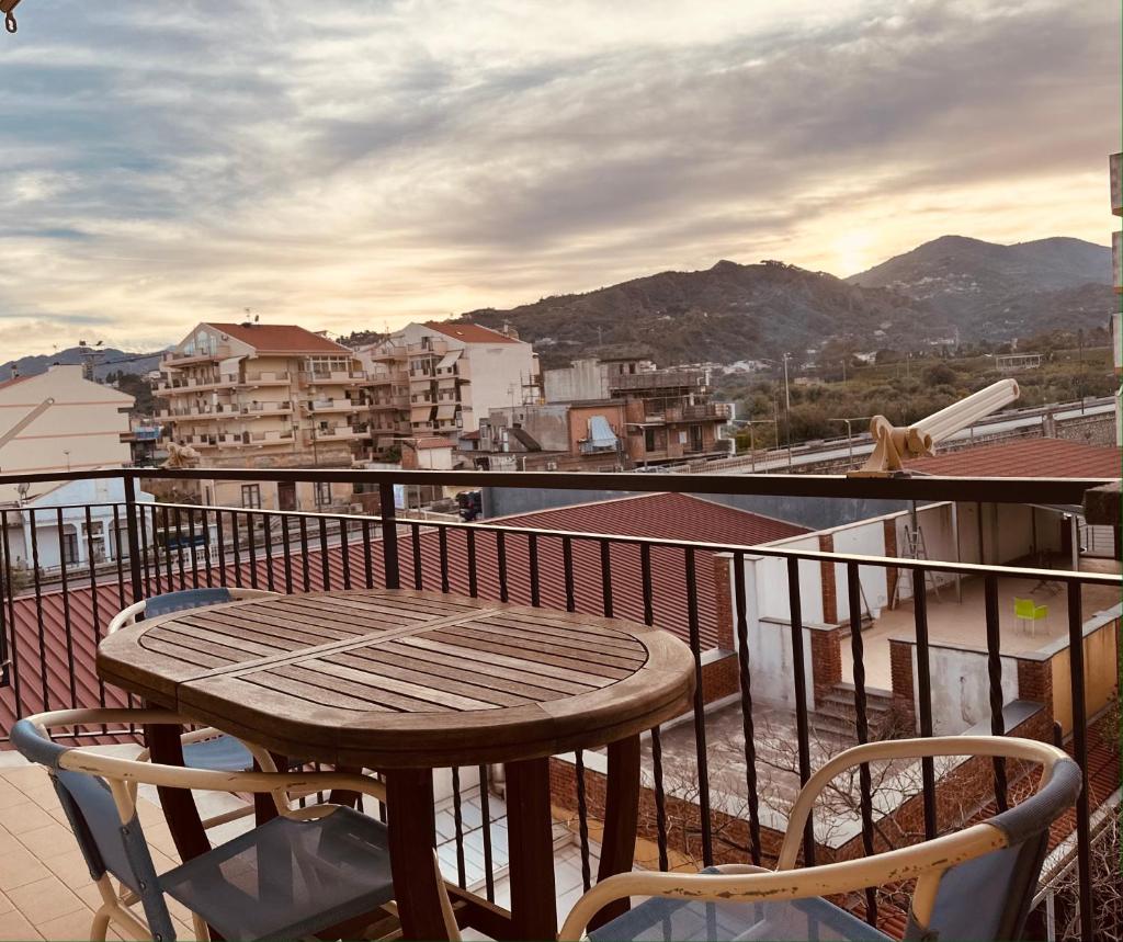 une table en bois et deux chaises sur un balcon dans l'établissement Riviera Ionica, à Santa Teresa di Riva