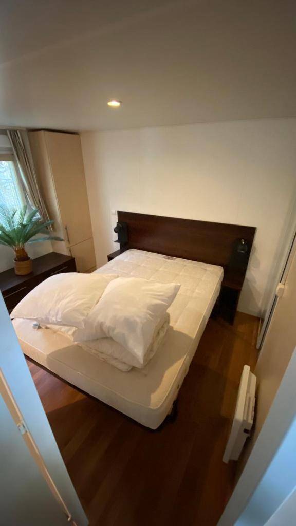 une chambre avec un lit avec des draps blancs et des oreillers dans l'établissement Mobilhome comfort à la montagne, à Saint-Auban 4 autres photos