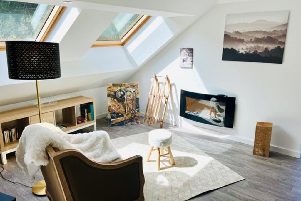 - un salon mansardé avec une lucarne et une cheminée dans l'établissement Pretty ski nest in Gérardmer, à Gérardmer